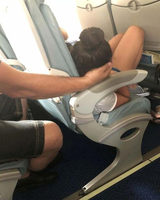 Dad sparks online debate after cradling daughter’s head for 45 minutes so she could sleep during a flight